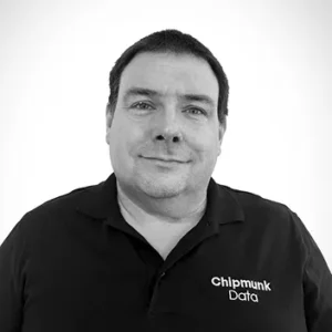 Comp Cloud – About Us6 Professional headshot man wearing Chipmunk Data black polo shirt