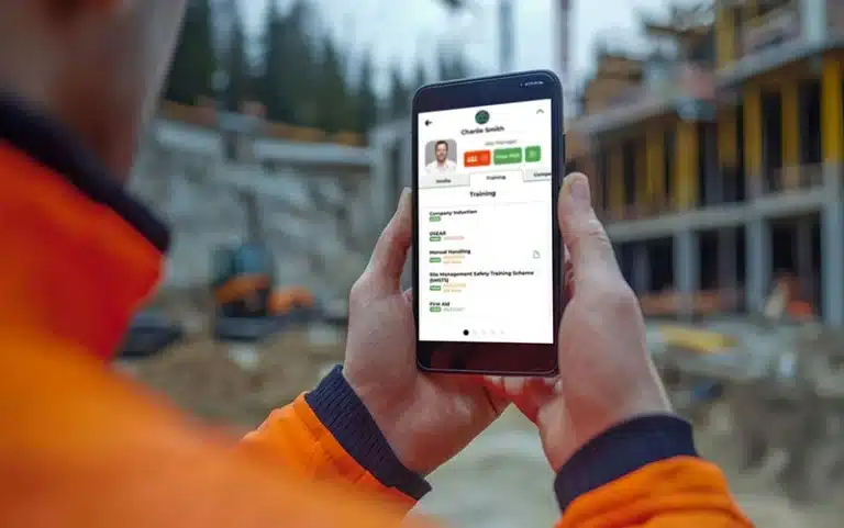 Construction worker holding smartphone displaying safety application on site