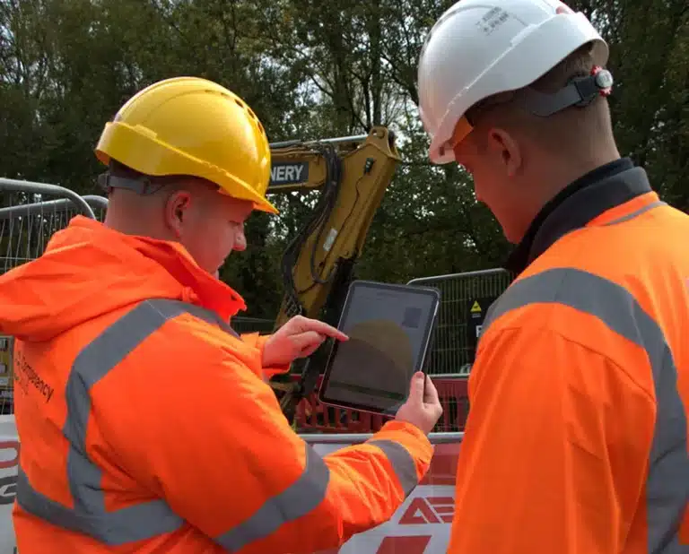 Construction workers reviewing plans on tablet device