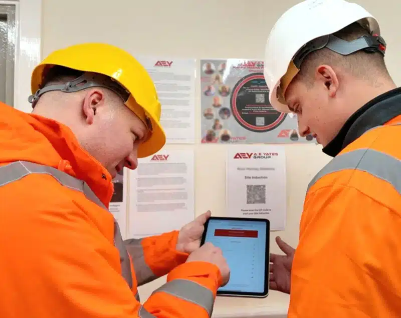 comprehensive-and-customisable-content-img Two construction workers in safety gear reviewing tablet
